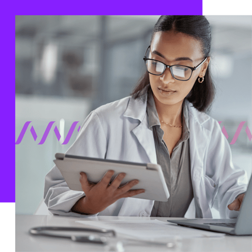 Image of a woman wearing a white coat and looking at a table screen